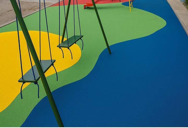 Piso emborrachado azul, verde e amarelo embaixo de balanços